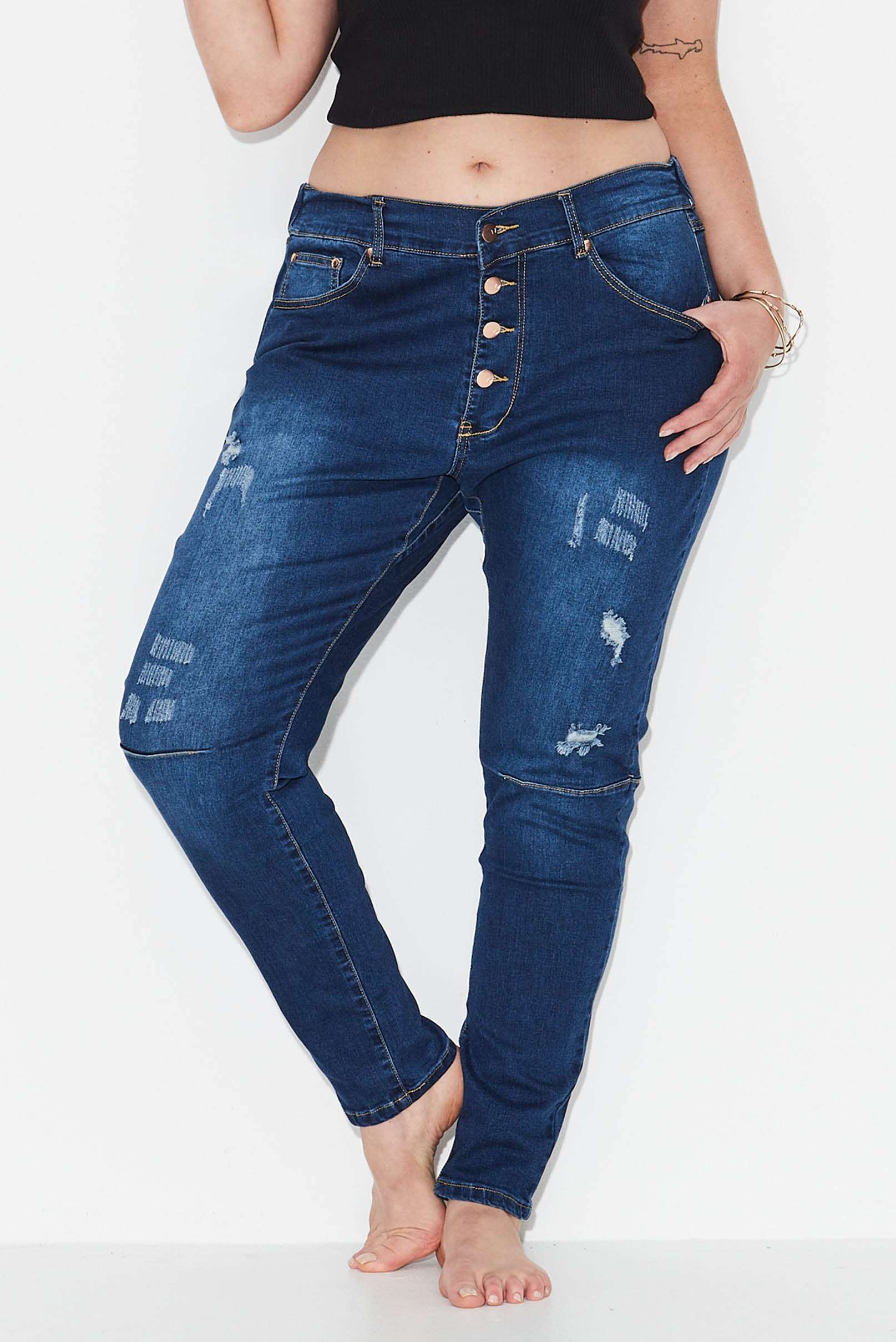 Model wears dark blue plus size tapered leg, ripped  jeans  