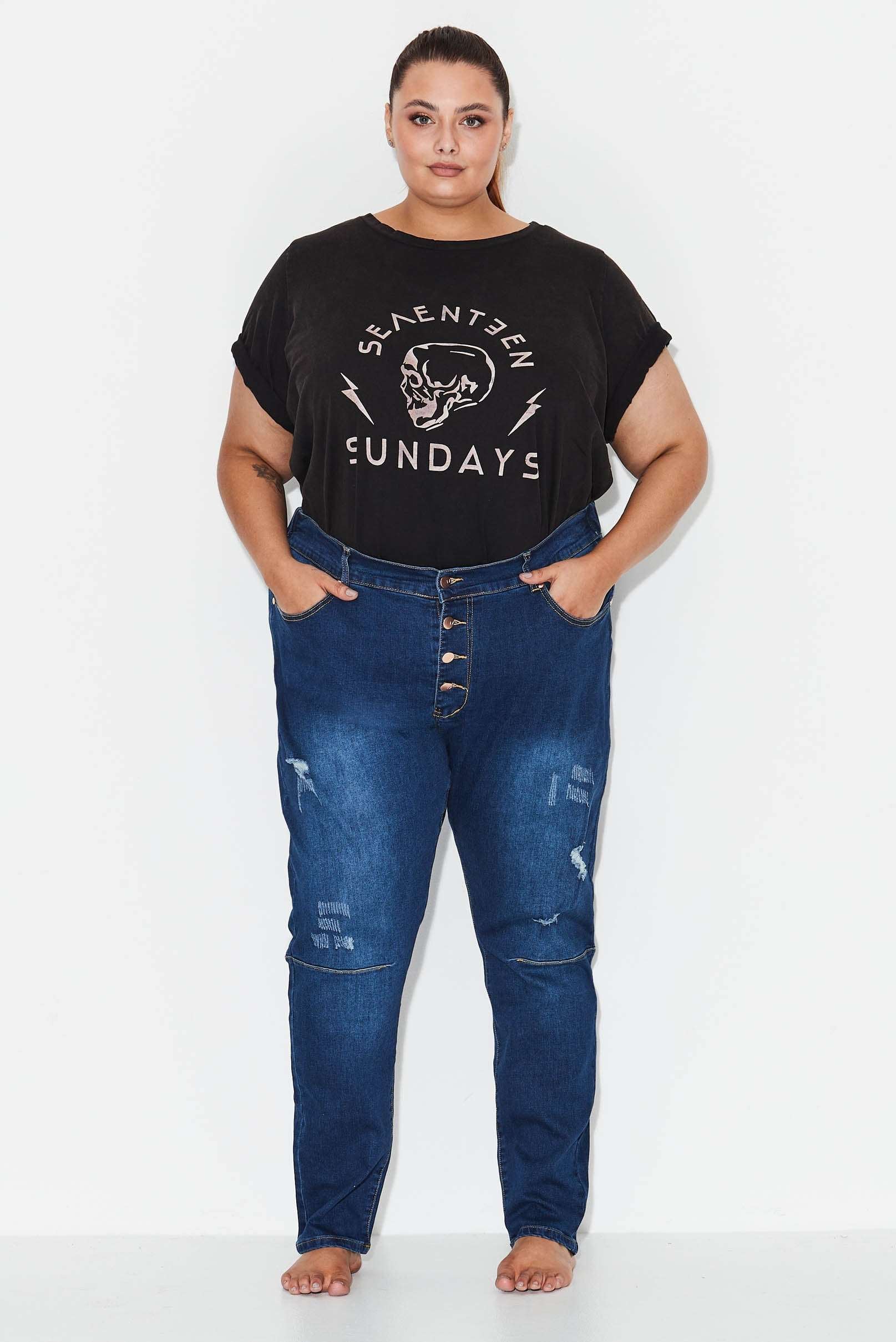 Model wears dark blue plus size tapered leg, ripped  jeans 