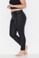 Model wears black plus size leather look jeans with exposed button front 