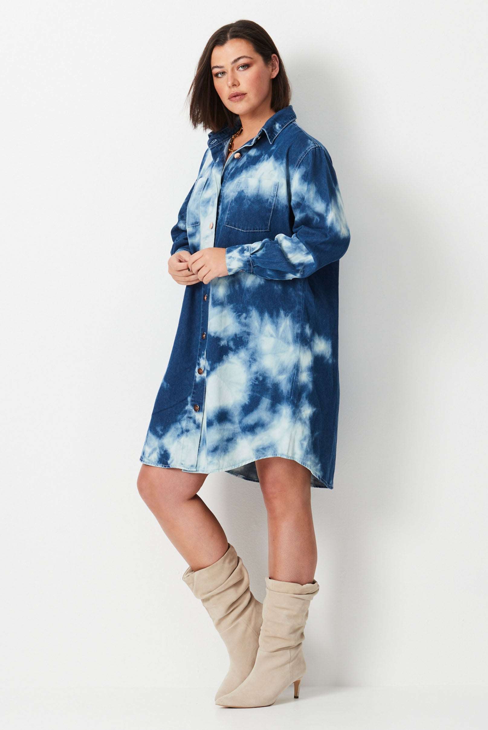 Model wears blue and white shibori tie dye plus size denim shirt dress 
