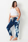 Model wears plus size dark blue tie dye denim jeans. with elastic waist and tapered leg.
