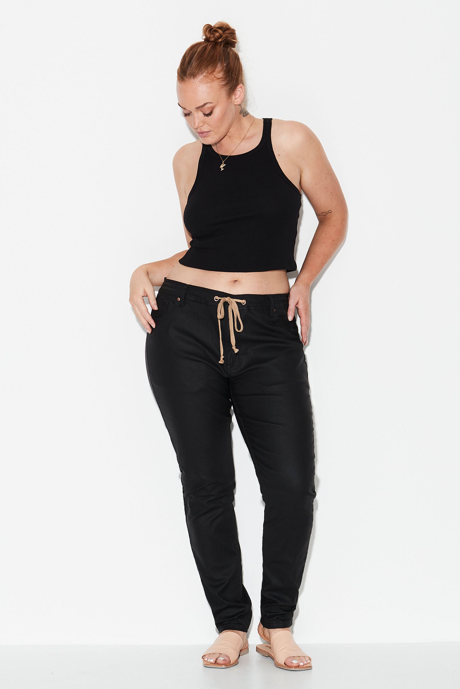 Model wears black leather look plus size jeans