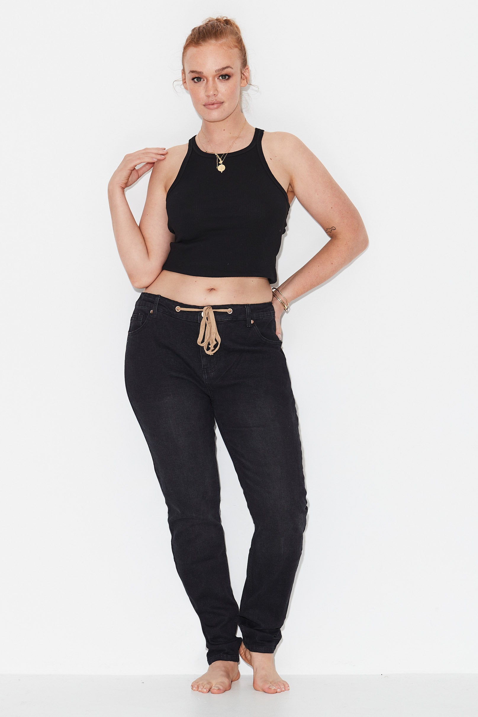 Model wears black slim leg plus size jeans
