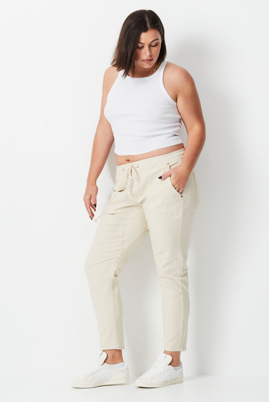model wears plus size jeans with elastic waist in bone colour